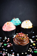 Tasty colorful cupcakes isolated on dark background. Delicious cupcake