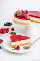 Berry jelly cake garnished with raspberries, blueberries and mint leaves