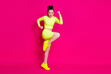 Fototapeta na wymiar Full size profile photo of astonished young lady stand fists up yell dress sport suit sneakers isolated on pink color background