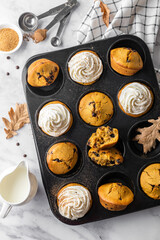 Pumpkin muffins with whipped cream on light background