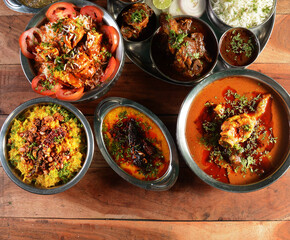 Assorted indian food Chicken gravy, paneer manchurian, dal tadka, poha and jeera rice..on wooden...
