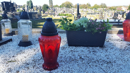 lanterns and flowers on grave at christian cemetery