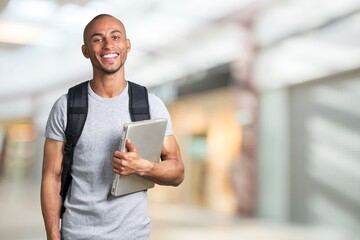 Smiling young black college student with laptop