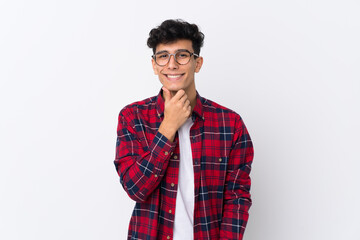 Young Argentinian man over isolated white background with glasses and smiling