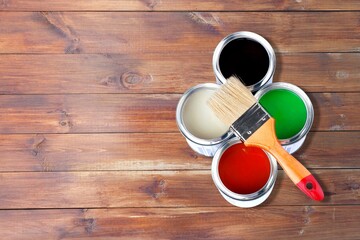 Different colorful paints in the metal can and brush