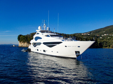 white super yacht power boat anchored at sea
