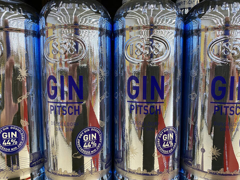 Viersen, Germany - July 9. 2020: View on shiny silver bottles Pitsch gin from D&uuml;sseldorf in shelf of german supermarket (focus on central bottles)