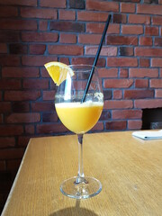 orange juice in a stemmed glass with a straw and orange slice