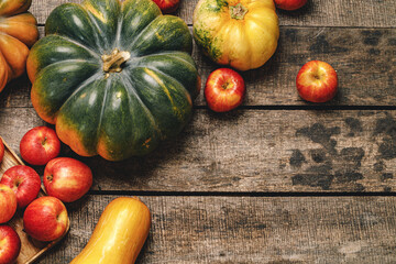 Autumn harvest of pumpkins and apples on wooden board