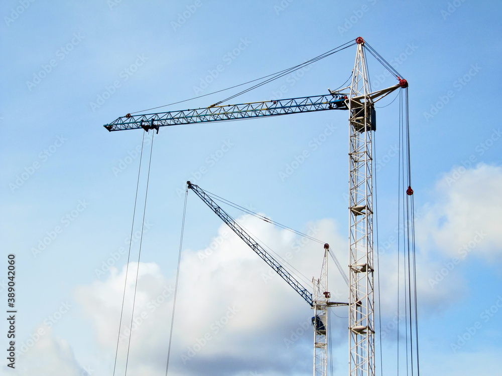 Wall mural Two construction cranes against the sky