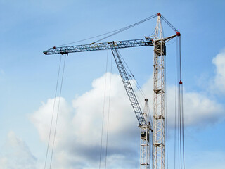 Fototapeta premium Two construction cranes against the sky