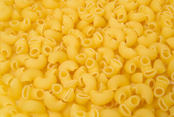 Background from macaroni pipa rigata. Raw, uncooked. Top view, close-up.