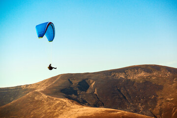 Paraglider flying in mountains. Paragliding concept. Beautiful nature carpathian mountains landscape.