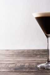 Martini espresso cocktail in glass on wooden table. Copy space