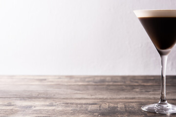 Martini espresso cocktail in glass on wooden table. Copy space