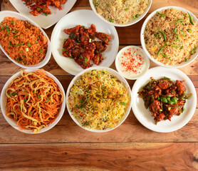 Assorted indian foods Dragon chicken,chicken biryani,chicken fried rice,veg noodles and garlic chicken on wooden background. Dishes and appetizers of indian cuisine