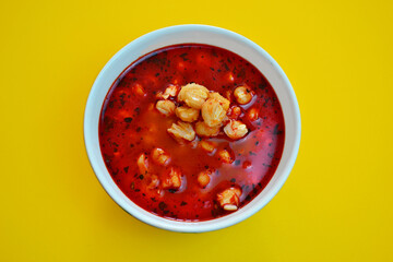 Mexican traditional plate of pozole a soup with corn and broth of red chili.