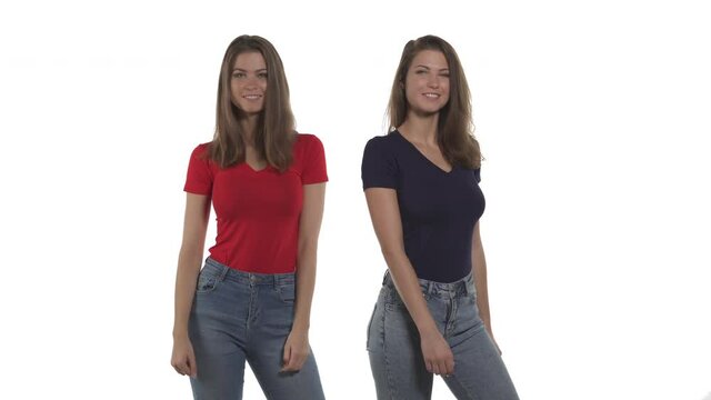 Funny Caucasian twin sisters doing hip swing move by bumping on buttocks each other. Isolated on white background
