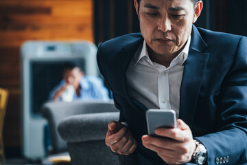 Serious business man using smartphone in cafe 