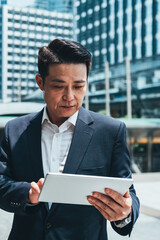 Fototapeta premium Portrait of serious business man using digital tablet in business district