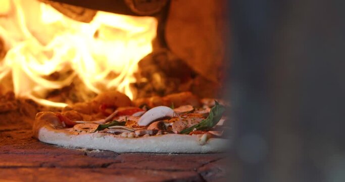 Traditional pizza in oven with flame