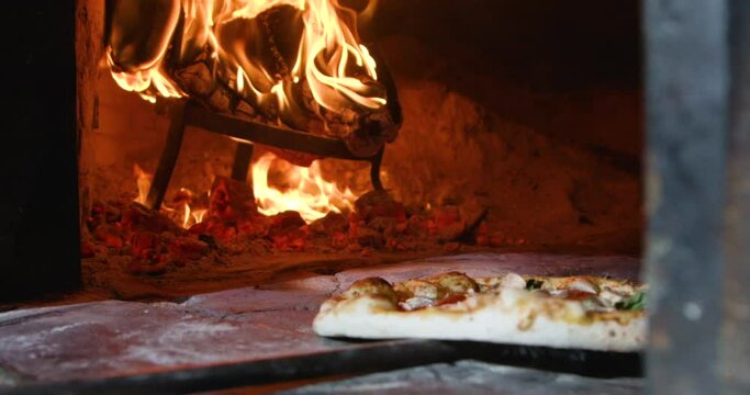 Chef turning pizza into oven