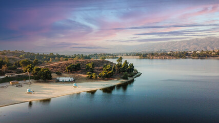 a stunning aerial shot of the still blue waters, the pier, the lush green trees and majestic...