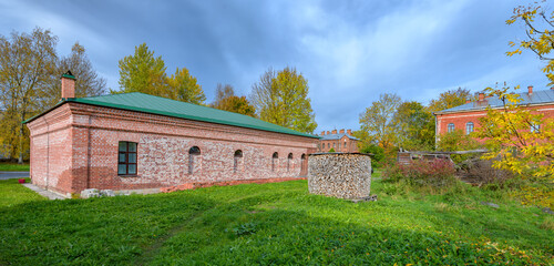 Different purpose buildings with red brick walls on the territory of the Old Ladoga Maiden Monastery on a sunny autumn day. Russia