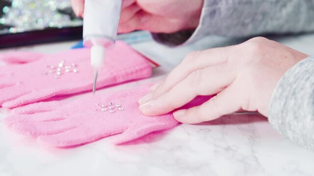 Rhinestone pink kids gloves with snowflake shapes.