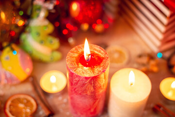Festive mood, warm colors, new year's eve. Colorful decorations on the table, focus on candles.