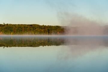 Light mist over a tranquil blue lake