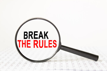 words BREAK THE RULES in a magnifying glass on a white background. business concept