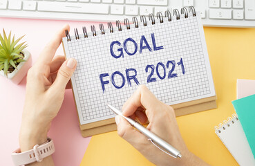 Goal 2021 text on opened notebook on the wood table, goal setting for coming year concept