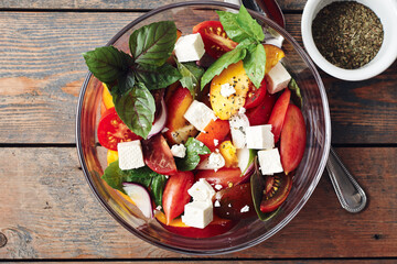 Salad with tomatoes, peach, red onion, feta cheese and basil.