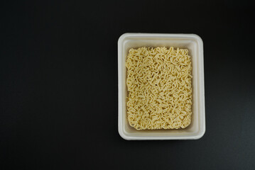 Dry instant noodles in rectangle plastic plate, top view