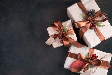 Three beautifully decorated gift boxes on a brown background. Concept of holiday backgrounds.