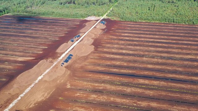 Aerial shot flying over peat harvesting field. Peat extraction