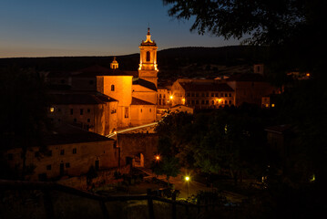 Fototapeta na wymiar City landscape of Santo Domingo de Silos with the famous Monastery of Silos illuminated at sunset, Burgos, Spain