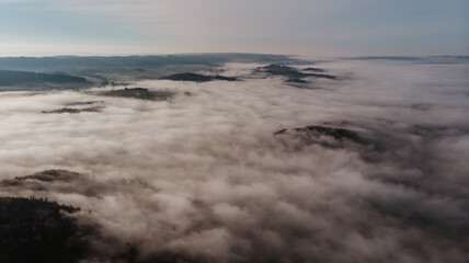Fototapeta na wymiar Aerial view of morning foggy landscape. Fall autumn peaceful scenery. Misty calm atmosphere. Drone photo of Czech mountains. Trees in fog. Fairy tale land.Meditation dreamy concept.