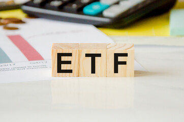 ETF - stock exchange text fund on wooden cubes, cubes lie on a financial chart