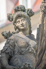 Old statue of a sensual woman warrior, Amazonian, as defender with flag at the Neumarkt in...