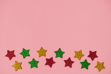 Colored shiny stars on a pink background. For use as a base for new year, Christmas and holiday compositions
