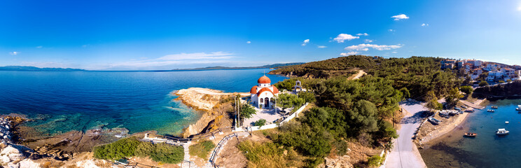 Fototapeta na wymiar Church and sea with beach and mountains in Nea Roda