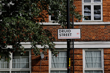 Fototapeta na wymiar A traditional London location sign named Druid street is seen in front of an apartment building in Southwark borough, London, United Kingdom.