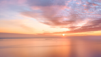 Fototapeta na wymiar Calm amber colored sea and sky at sunset