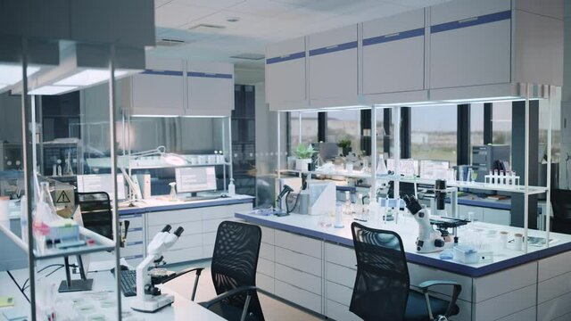 Modern Empty Biological Applied Science Laboratory with Technological Microscopes, Glass Test Tubes, Micropipettes and Desktop Computers and Displays. PC's are Running Sophisticated DNA Calculations.