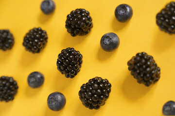 Blackberries and blueberries on an illuminating background. High quality photo