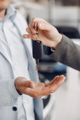 Man buying the car. Businessman in a car salon. Assistant with a client