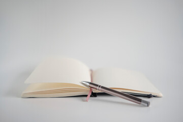 Opened notebook with pen on a white desk