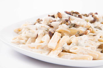 Pasta with blue cheese and cream sauce, sprinkled with roasted pumpkin seeds